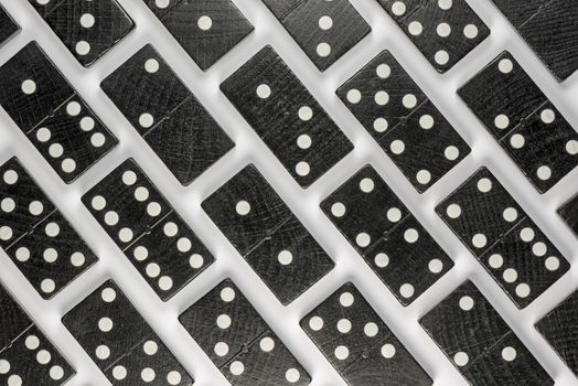 Composition of lying black domino bricks with white dots
