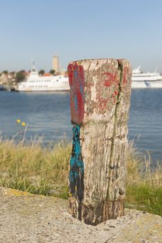 Old weathered and beautifully colored mooring pole in the harbor of West-Terschelling in the North of the Netherlands
