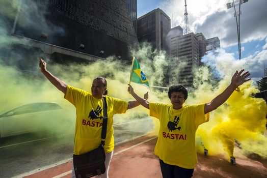 BRAZIL, Sao Paulo: Two demonstrators raise their hands and wear a t-shirt reading Basta! during a protest for the impeachment of President Dilma Rousseff, against former president Lula and against corruption in Petrobras scandal case in Sao Paulo, Brazil on March 26, 2016. Brazilian lawmakers relaunched impeachment proceedings against President Dilma Rousseff Thursday and a judge blocked her bid to bring her powerful predecessor into her cabinet, intensifying the political crisis engulfing her. 