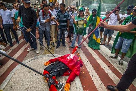BRAZIL, Sao Paulo: Demonstrators destroy symbols of ruling party,  Workers' Party (PT) during a protest for the impeachment of President Dilma Rousseff, against former president Lula and against corruption in Petrobras scandal case in Sao Paulo, Brazil on March 26, 2016. Brazilian lawmakers relaunched impeachment proceedings against President Dilma Rousseff Thursday and a judge blocked her bid to bring her powerful predecessor into her cabinet, intensifying the political crisis engulfing her. 
