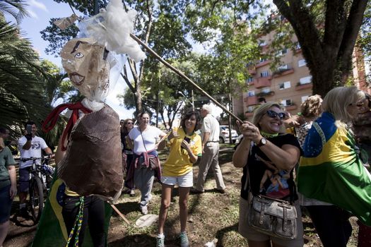 BRAZIL, Curitiba: Protesters beat effigies of President Dilma Rousseff and former President Lula in front of the Federal Court in Curitiba, Brazil on March 26, 2016. Traditionally on the Saturday before Easter, Catholics beat effigies of Judas the apostle. This year protesters in favor of impeachment of the President of Brazil, used the tradition as a political demonstration.