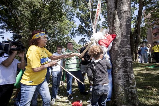 BRAZIL, Curitiba: Protesters beat effigies of President Dilma Rousseff and former President Lula in front of the Federal Court in Curitiba, Brazil on March 26, 2016. Traditionally on the Saturday before Easter, Catholics beat effigies of Judas the apostle. This year protesters in favor of impeachment of the President of Brazil, used the tradition as a political demonstration.
