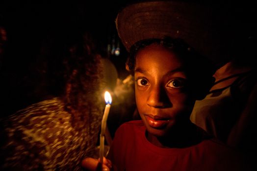 BRAZIL, Sao Paulo: A boy holds a candle as churchgoers attend Easter mass and vigil at São Paulo See Metropolitan Cathedral on March 26, 2016. Christians around the world are marking the Holy Week, commemorating the crucifixion of Jesus Christ, leading up to his resurrection on Easter.