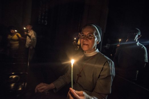 BRAZIL, Sao Paulo: Churchgoers hold candles as they attend Easter mass and vigil at São Paulo See Metropolitan Cathedral on March 26, 2016. Christians around the world are marking the Holy Week, commemorating the crucifixion of Jesus Christ, leading up to his resurrection on Easter.