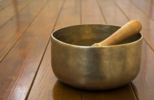 Metal singing bowl on a wooden surface