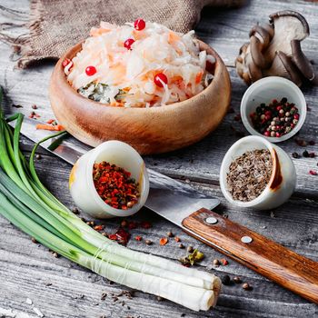 Sauerkraut and spices on wooden background in rustic style