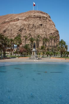 High cliff of Morro de Arica towering above Plaza Vicuna Mackenna in the heart of the port city of Arica in Chile.