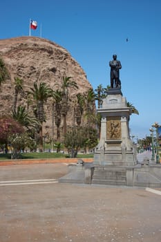 Statue of Vicuna Mackenna in the Plaza of the same name in the heart of the port city of Arica in Chile. Morro de Arica in the background.