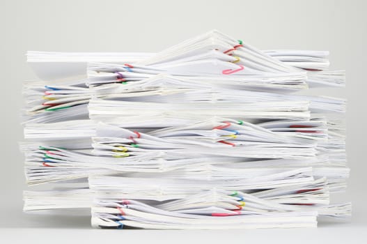 Overload document of report and receipt with colorful paperclip on white table.