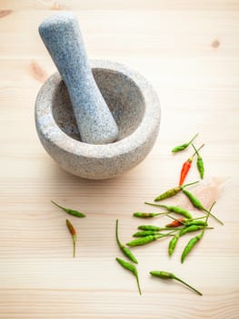 Fresh Chillies on white wooden background with mortar and pestle. Selective focus depth of field.