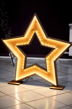 Homemade diy wooden star with led lighting on the floor and decoration events.