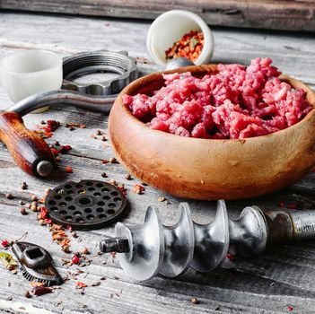 Wooden dish, with meat and parts of the disassembled grinder