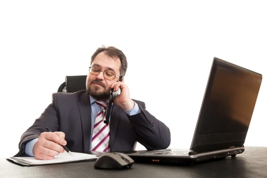 the businessman communicates by phone sitting at a table and makes entry