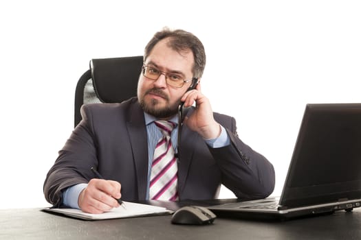 the businessman communicates by phone sitting at a table and makes entry