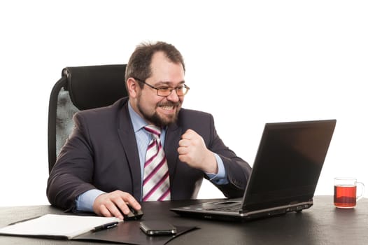 the businessman sits at office table with the laptop