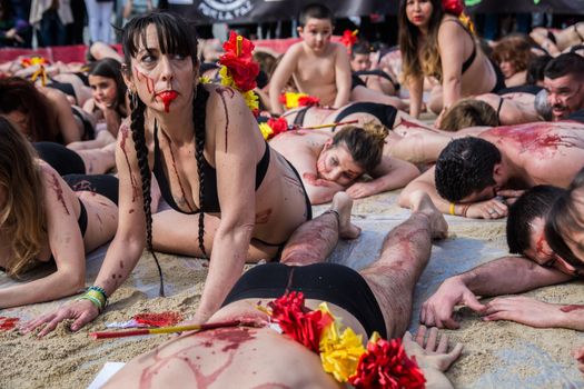 SPAIN, Madrid: Anti-bullfighting protesters covered with red paint as if it is blood gather at Puerta del Sol square, in Madrid, on March 27, 2016 against bullfights. They have turned the iconic square of Puerta del Sol into a bullring. Protesters demand the abolition of bullfights under the slogan  The bull suffers!