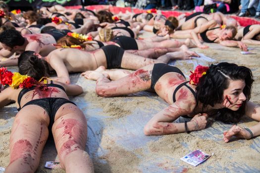SPAIN, Madrid: Anti-bullfighting protesters covered with red paint as if it is blood gather at Puerta del Sol square, in Madrid, on March 27, 2016 against bullfights. They have turned the iconic square of Puerta del Sol into a bullring. Protesters demand the abolition of bullfights under the slogan  The bull suffers!