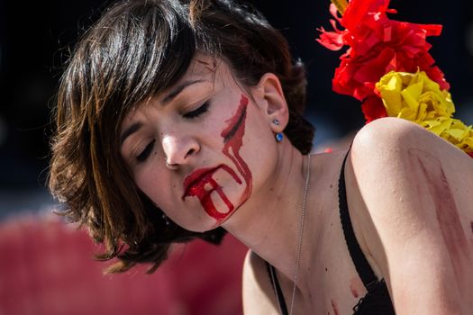 SPAIN, Madrid: Anti-bullfighting protesters covered with red paint as if it is blood gather at Puerta del Sol square, in Madrid, on March 27, 2016 against bullfights. They have turned the iconic square of Puerta del Sol into a bullring. Protesters demand the abolition of bullfights under the slogan  The bull suffers!
