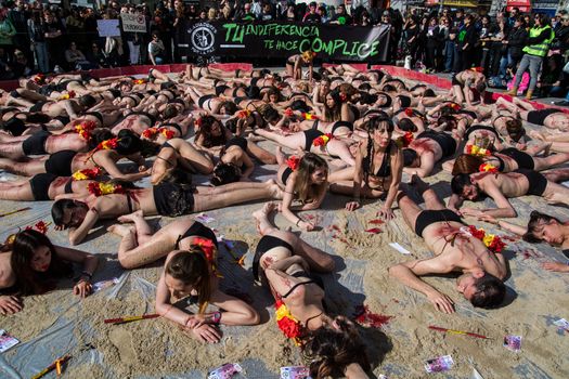 SPAIN, Madrid: Anti-bullfighting protesters covered with red paint as if it is blood gather at Puerta del Sol square, in Madrid, on March 27, 2016 against bullfights. They have turned the iconic square of Puerta del Sol into a bullring. Protesters demand the abolition of bullfights under the slogan  The bull suffers!
