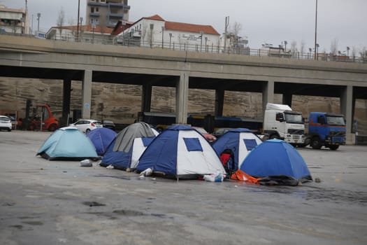 GREECE, Athens: Refugees continue to camp out under the rain, as thousands are still stranded at the Port of Piraeus in Athens, Greece on March 27, 2016. A deal between the European Union and Turkey has aimed to curb the influx of refugees to Greece, saying reception centers have become detention facilities. 