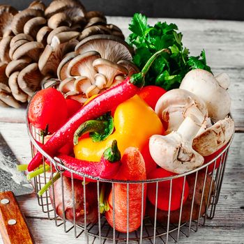 Fresh mushrooms,tomatoes,peppers and onions on a light wooden background