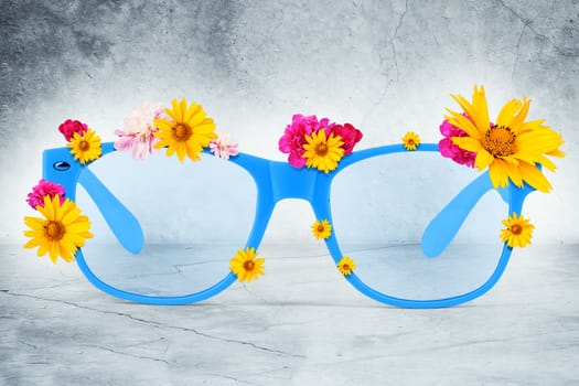 Glasses with flowers on grey wall background