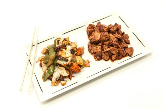 The Chinese fried beef in sweet-sour sauce and stewed vegetables. On a white background