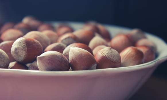 hazelnuts with shells in a plane on wooden table