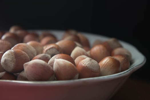 hazelnuts with shells in a plane on wooden table