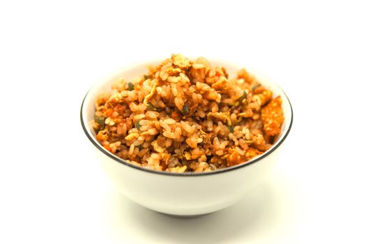 Fried Chinese rice with vegetables and egg, in a bowl on a white background. Chinese favourite garnish