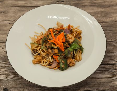 The Chinese fried noodles with squids, an octopus and vegetables