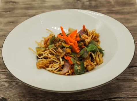 The Chinese fried noodles with squids, an octopus and vegetables