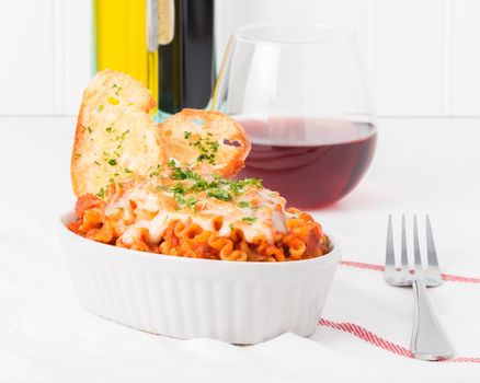 Baked lasagna served with toasts and red wine.