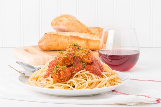 Traditional Italian spaghetti and meatballs served with fresh bread and wine.