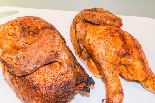 Beautiful brown grilled chicken legs on white plate.
