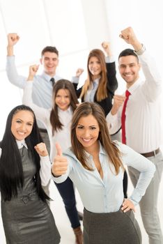 Group of young successful business people standing with thumbs up and lookingat camera.