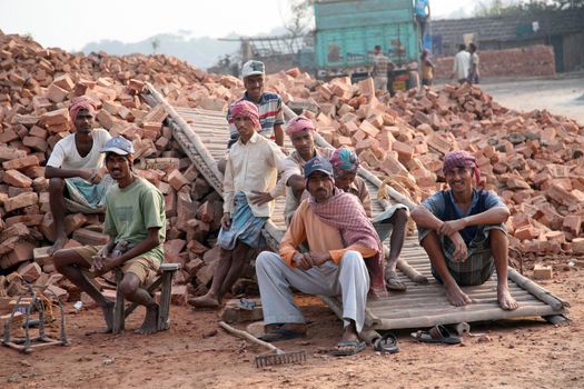 Brick field workers rest after hard work, wearing just baked brick from the kiln in truck on January 16, 2009 in Sarberia, West Bengal, India.