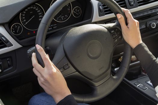 the girl with the manicure keeps hands on the steering wheel of the car