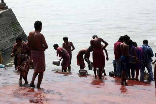 Hindu people bathing in the ghat near the Dakshineswar Kali Temple in Kolkata, West Bengal, India