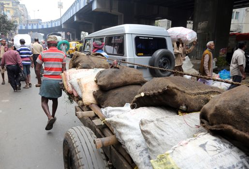 Hard working Indians pushing heavy load through streets in Kolkata, India. Human labour is still cheaper than motorised vehicles.