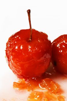 Red apples in rose syrup with small pieces of zucchini over isolated white background