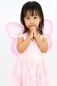 Chinese little girl wearing butterfly custome with praying gesture in plain white background