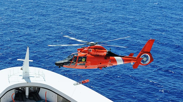 Rescue helicopter next to ship bow in operation