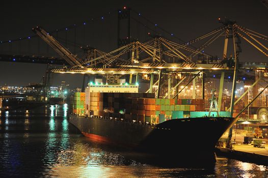 Cargo ship in port with containers at night