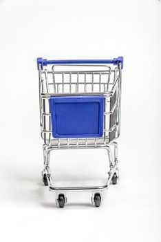 Close up of a little shopping cart with blank sign on front for your copy.
