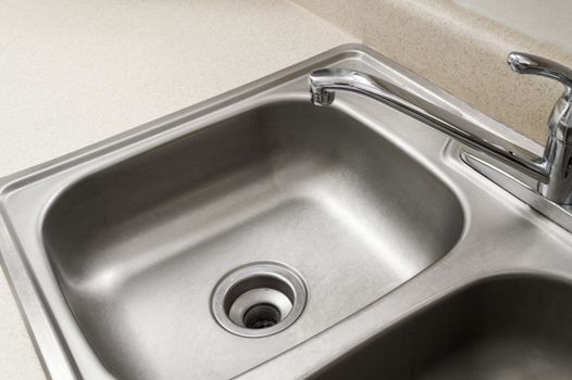 Abstract angle of a stainless steel sink with drain in the center.