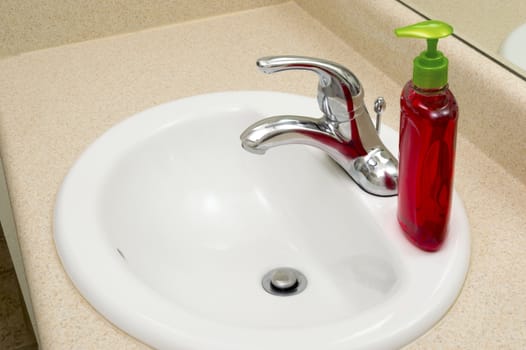 Beautiful clean horizontal shot of bathroom sink with liquid soap ready to use.