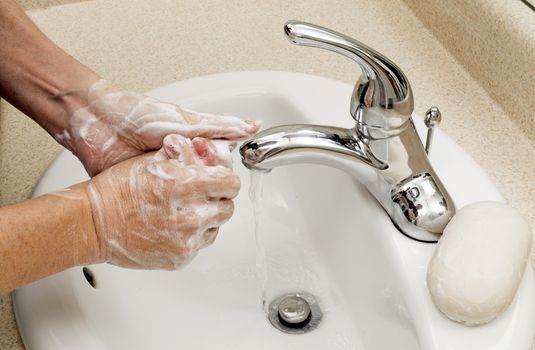 Showing good hygiene, a woman washes her hands.