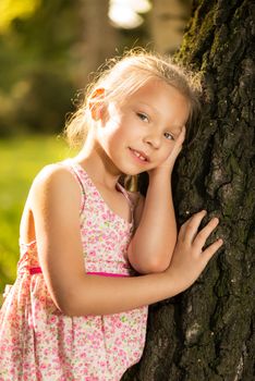 Cute little girl on the tree in the park