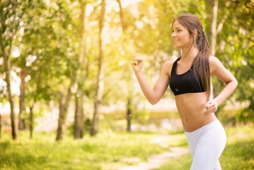 Happy young beautiful woman running in the park